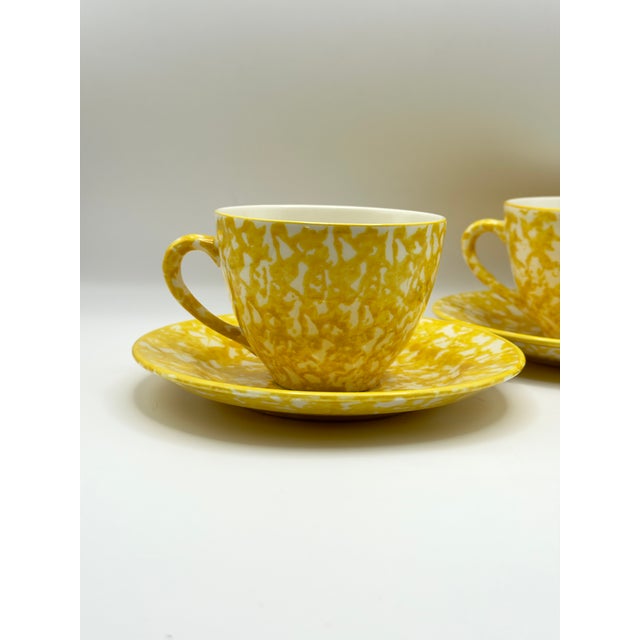 A cheerful vintage set of yellow spongeware teacups with matching saucers, made in the USA for Royal Copenhagen under the...