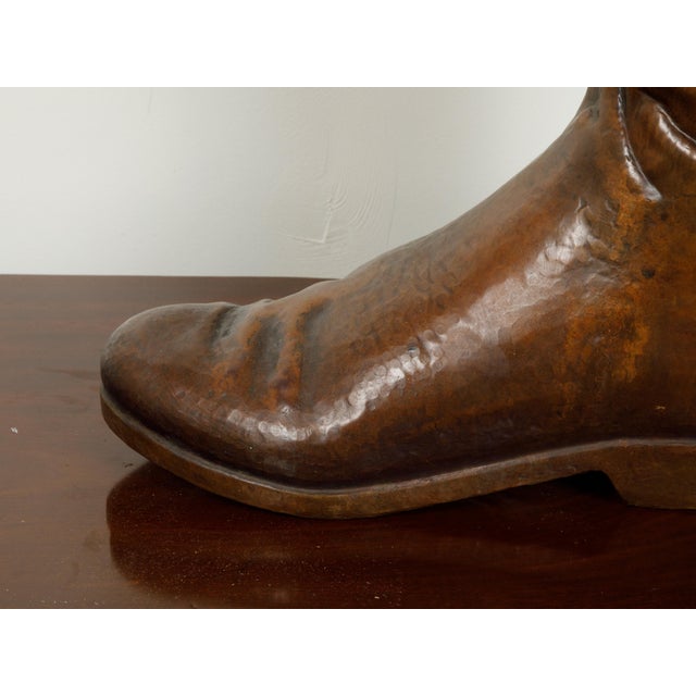 An English copper umbrella stand from the mid 20th century, depicting a boot. Created in England during the Midcentury...