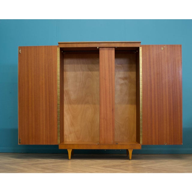 1960s Stonehill Furniture teak wardrobe with recessed handles and tapering legs. Internally it has a full-width hanging...