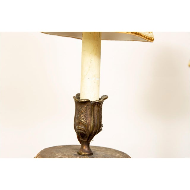 A pair of 19th-century gilded wood two-arm wall sconces with scrolling, acanthus-leaf-carved arms, tulip-shaped bronze...