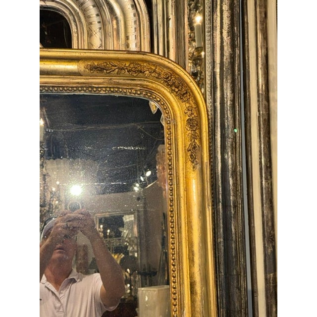 The product is a 19th century French Louis Philippe mirror adorned with intricate flower designs, adding a touch of...