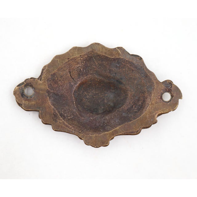 Baroque style furniture applique made of brass. It features ornate acanthus leaf scrolls framing a central fan-shaped...