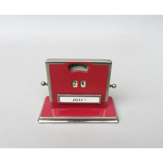 A perpetual calendar by Jakob Maul from the 30s/40s. Elegant lacquering in old pink in combination with chrome (chrome-...