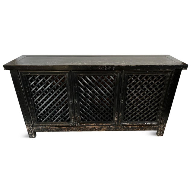 Vintage aged black finish solid wood sideboard with three doors featuring lattice cutout design. Great used as a bar...