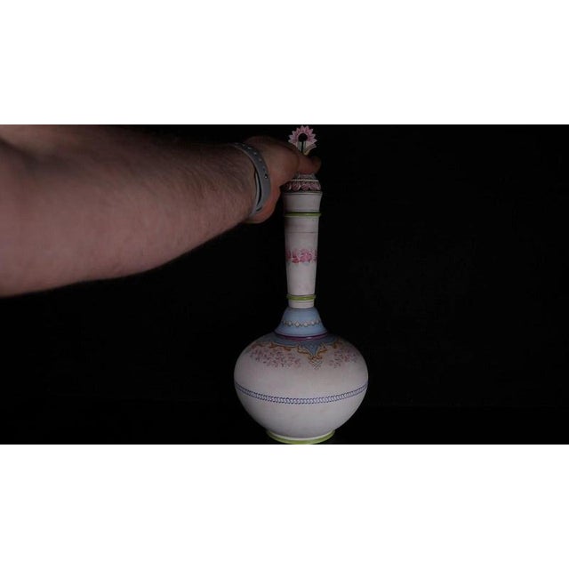 A bulbous lower body tapering into a tall cylindrical neck defines this French unglazed porcelain bottle vase, fitted with...