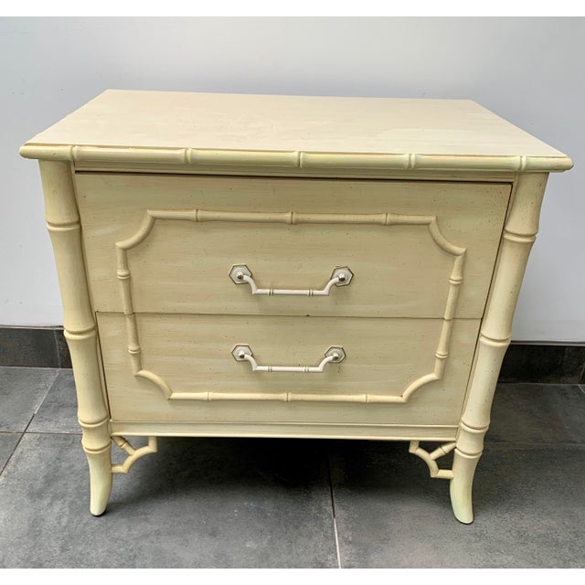 A vintage faux bamboo Dixie nightstand with fretwork and two drawers with original pulls. This style is often called...