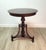A refined mahogany pedestal table in the American Classical tradition, featuring a circular top raised on a beautifully...