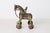 An antique hand-cast brass horse with mounted rider on four ornately decorated wheels, in the Indian temple toy tradition....
