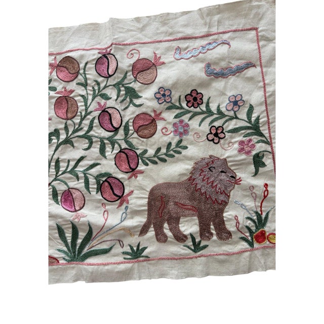 Hand-embroidered Suzani panel from Uzbekistan, worked in fine floss on a cream cotton ground. Three lions move across the...