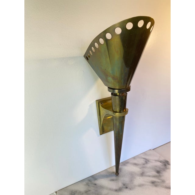 Exceptional vintage Gilbert Poillerat brass wall sconce from the 1950s. Hand-crafted French modernist design with...