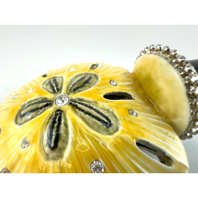 Bring a splash of coastal charm and a hint of vintage glam to your barware collection with this dazzling sand dollar...