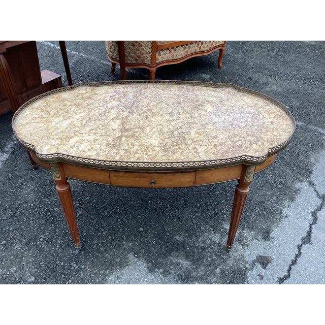 Handsome and elegant best describe this French Louis XVI-style coffee table. This piece features a stunning marble top...