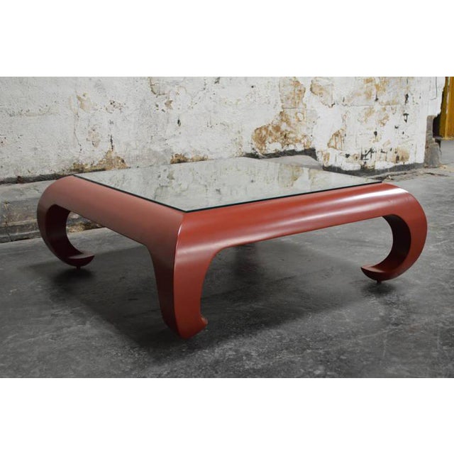 Chinoiserie Ming style Coffee Table in Chinese red. Table features curved scroll legs with a custom vintaged mirror top....