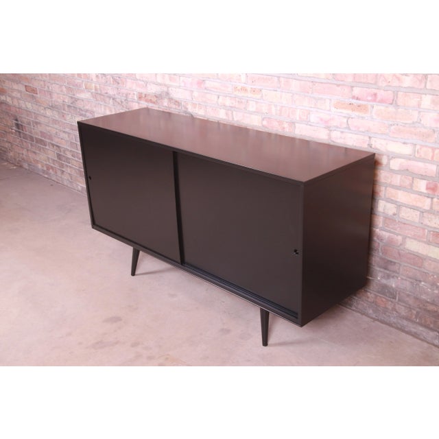 An exceptional minimalist mid-century modern sliding door sideboard, credenza, or bar cabinet By Paul McCobb for...