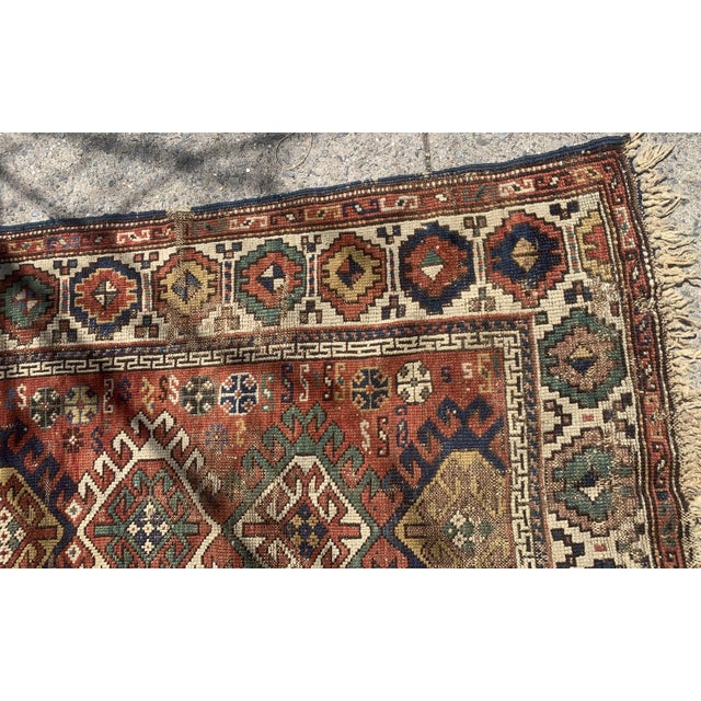 Handmade antique Caucasian Kazak rug in red color. The rug is from the end of 19th century in distressed condition....
