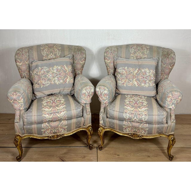 Elegant pair of armchairs in Louis XV style, featuring gracefully curved silhouettes and carved giltwood bases with...