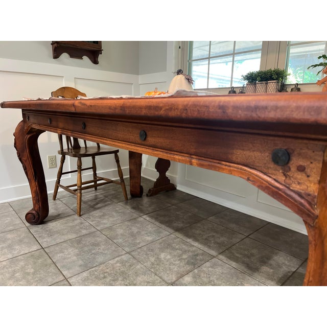 Beautiful substantial solid mesquite wood dining table featuring beautifully carved legs and a warm, richly grained...