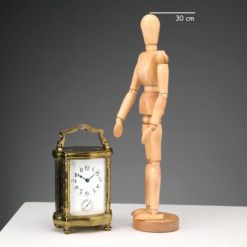 Gilded bronze travel clock with beveled glass and visible movement with cylinder escapement. Enamelled metal dial with...