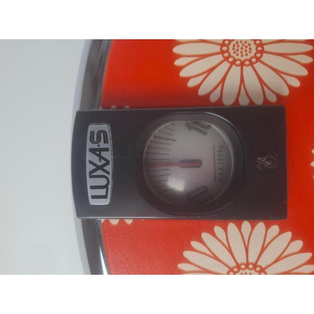 A mid-century Luxas scale produced in Czechoslovakia featuring a vivid orange floral design with a chrome border....