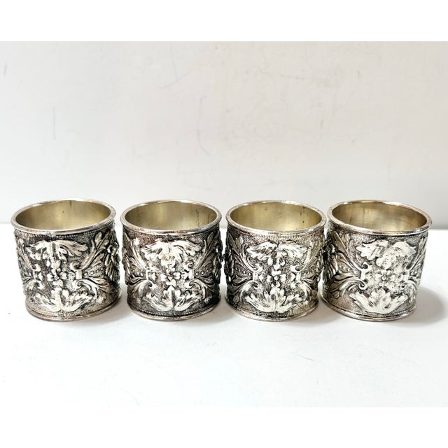 A bold set of vintage silverplate napkin rings featuring sculptural lion head medallions framed by scrolling acanthus...