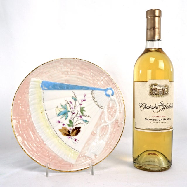 A colorful and artistic cabinet plate with a hand painted fan design. The porcelain plate has a molded a basket weave...