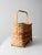A vintage American splint basket featuring a footed base, arched handle, and classic flat-splint weave accented with soft...