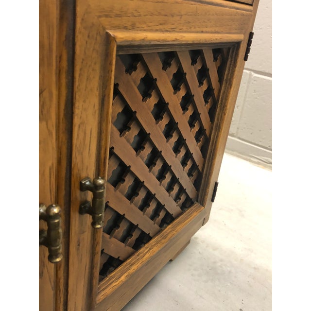 This Esperanto by Drexel side table notes eye catching lattice work on the front of the doors and casters underneath for...