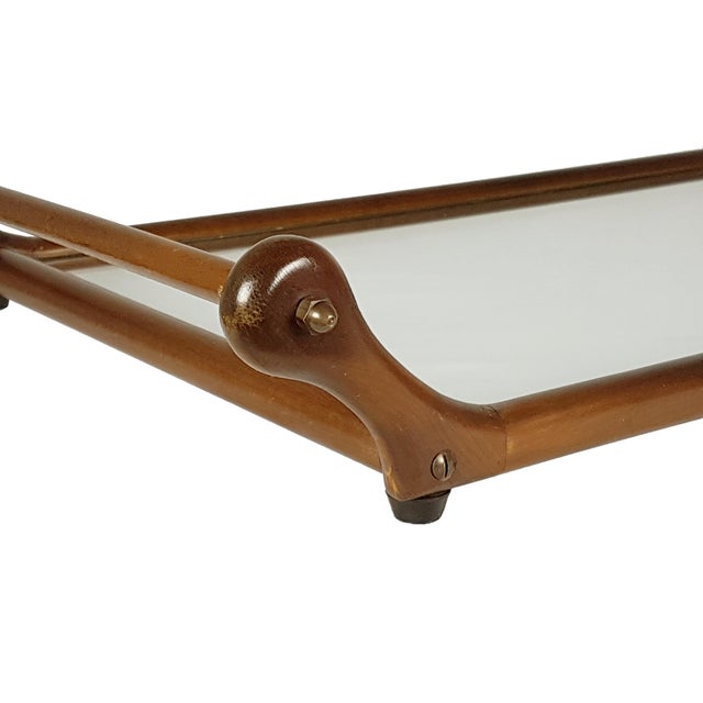 This sculptural serving tray with shaped handles is made from wood, brass and glass tray. It remains in very good condition.