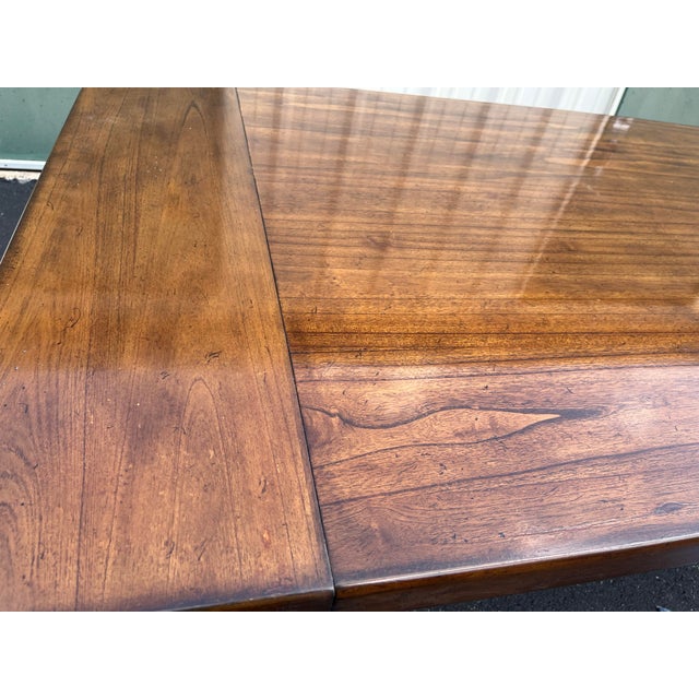 Walnut extension dining table in a rustic or farmhouse style. This beautiful table rests on four large stout farmhouse...