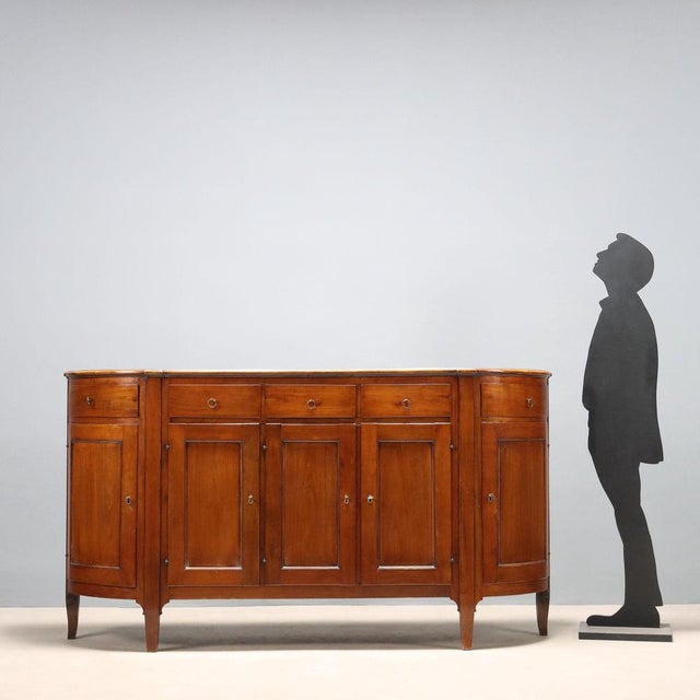 Rounded cherry sideboard. Front with three drawers under the top and three paneled doors, rounded sides with an under-top...