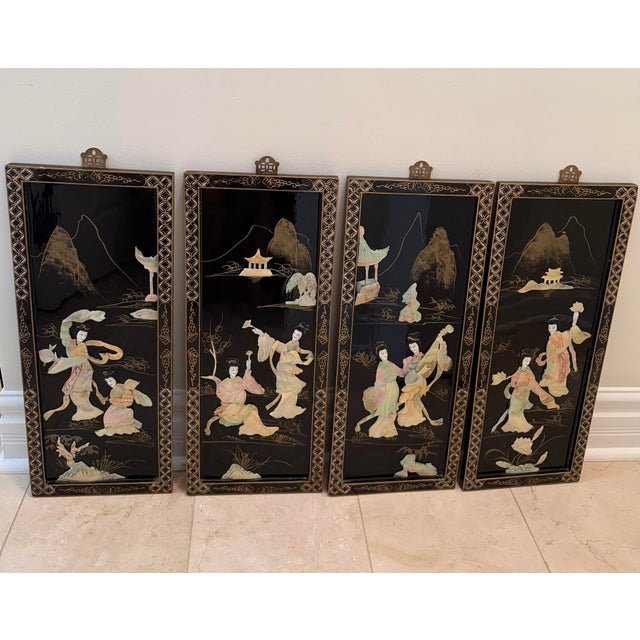 A decorative set of four vintage mid 20th century black lacquer wall panels featuring hand-carved pastel mother-of-pearl...