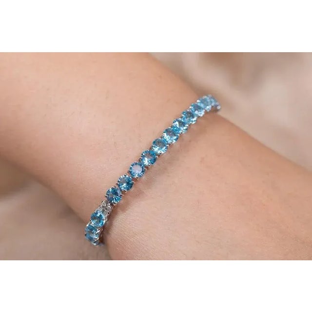 This is part of Chairish’s Fine Jewelry assortment. This Sparkling Diamonds and Blue Topaz Tennis Bracelet in 18K gold...