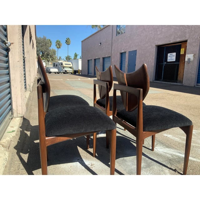 Mid century style solid walnut dining chairs. The chairs are is the style of Kurt Ostervig butterfly iconic butterfly...