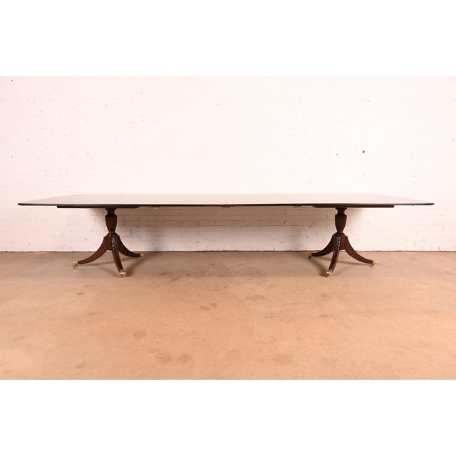 An exceptional Georgian or Regency style double pedestal extension dining table In the manner of Baker Furniture USA,...