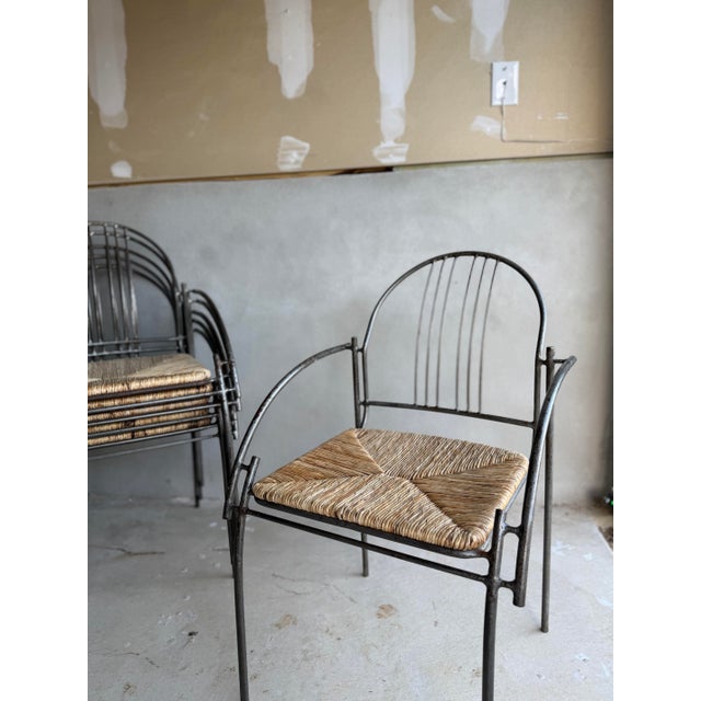 Set of 6 heavy steel metal chairs with rush woven seats. Curved sculptural arm and back. Use indoor or covered outdoor....