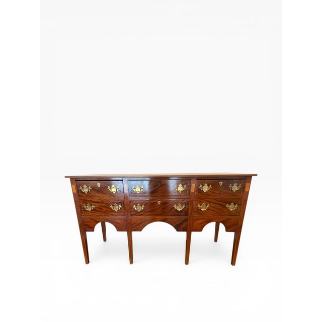 A refined early 20th century Federal Revival sideboard, showcasing beautifully figured flame mahogany veneers and elegant...
