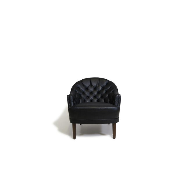 Pair of Danish armchairs with rounded, sculptural backs upholstered in the original black leather with classic button-...