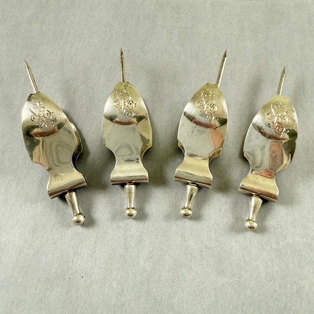 A set of four extremely scarce and unusual sterling silver lemon slice squeezers, Birmingham, England, date marked 1909....