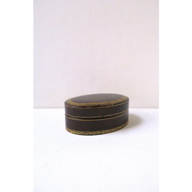 An oval Italian rich dark brown leather jewelry box with gold embossed design, circa mid-20th century, 1940s - 1950s,...