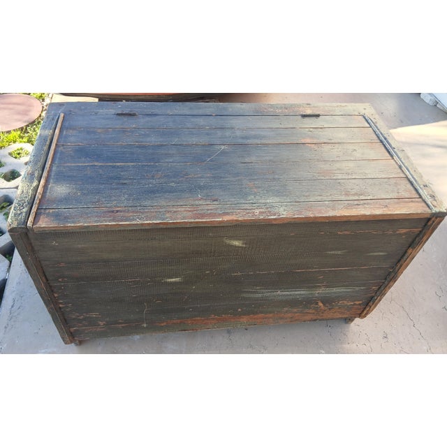 Based on the visible grain structure, this trunk or chest's wood is old-growth pine. The bold, distinct, dark and light...