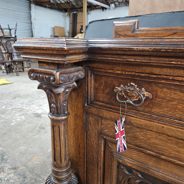 This statement piece sideboard has heavily carved art nouveau door panels and is flanked by a pair of ornate columns. This...