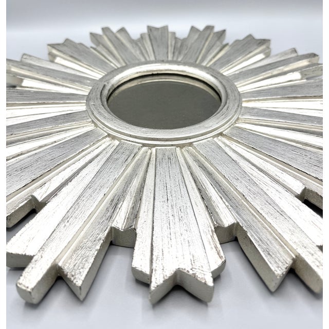 Stunning sunburst mirror with painted silver wood and a smokey glass finish. This decorative mirror is the perfect...