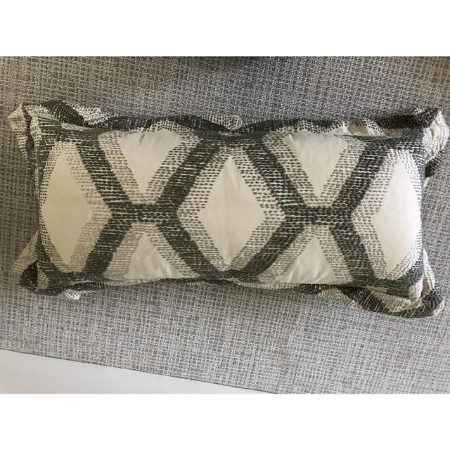 Custom lumbar grey and cream embroidered pillows. This set of three features geometric embroidered detailing in a...