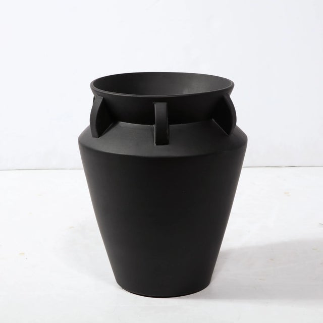 This elegant modernist urn form vase was realized in the United States during the latter half of the 20th century. It...