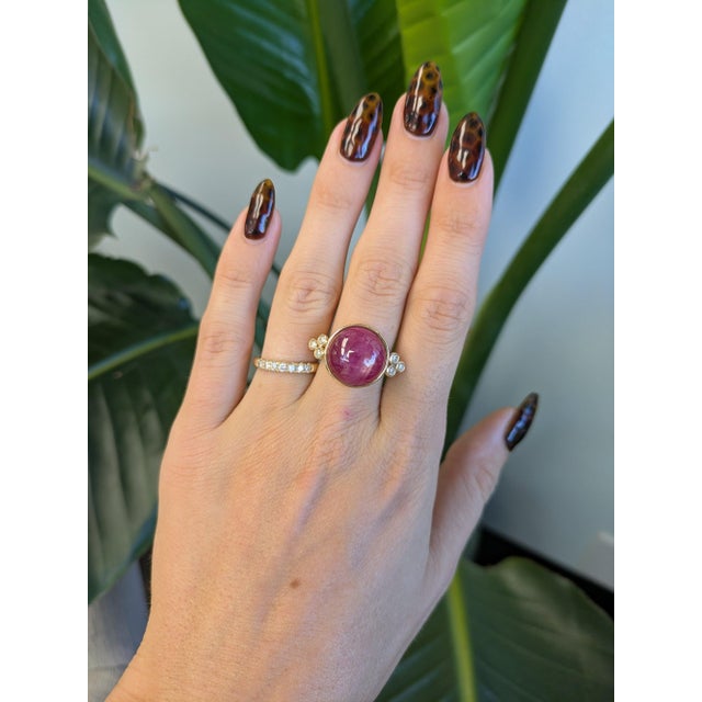 A remarkable 19.91-carat star ruby displays a striking six-rayed star across its large round cabochon, set in solid 14K...