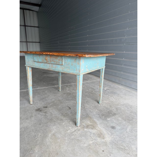 This 19th Century Primitive English Work Table features a distressed light blue painted base and a natural wood top. With...