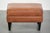 This handy sheepskin footstool features a warm color scheme and is finished with black piping. A footstool, also known as...