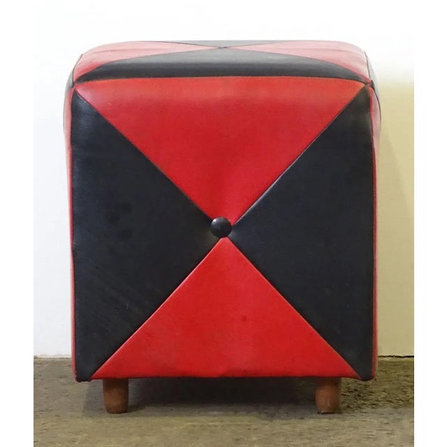 This stool from the turn of the 1950s and 1960s features its original red and black leatherette upholstery.