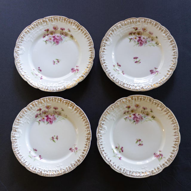 A set of four CT Carl Tielsch porcelain scalloped dessert plates, hand-painted with delicate pink and green florals that...