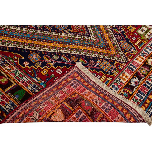 Beautiful Vintage Shiraz hand-knotted Wool rug with the red field. This Shiraz rug has a multicolor accents in all over...